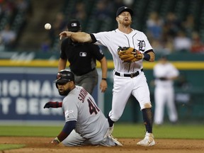 Detroit Tigers second baseman Gordon Beckham attempts to turn the double play against Cleveland Indians right fielder Yasiel Puig and first baseman Carlos Santana during the sixth inning at Comerica Park.