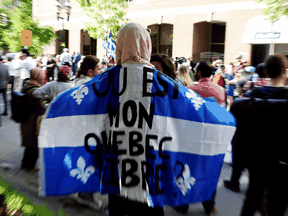 A woman holds a flag with the slogan "Where is my free Quebec" while protesting Quebec's Bill 21, which will ban teachers, police, government lawyers and others in positions of authority from wearing religious symbols such as Muslim head coverings and Sikh turbans.