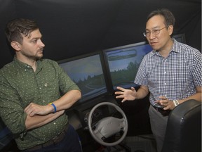 Assissant professor of human kinetics, Francesco Biondi, left, and associate professor of civil engineering engineering Chris Lee are pictured next to a driving simulator at the University of Windsor, Wednesday, August 21, 2019.