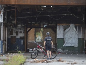 A Windsor police officer takes a look at 840 Wyandotte St. East on Aug. 8, 2019. The abandoned restaurant property has become a hangout for drug addicts.