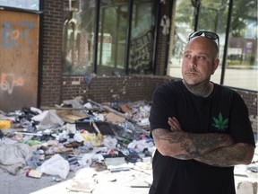Andrew Steptoe stands inside the remains of 840 Wyandotte St. East on Aug. 8, 2019. A nearby business owner, Steptoe is alarmed by the burnt-out building's squalor and occupancy by drug users.