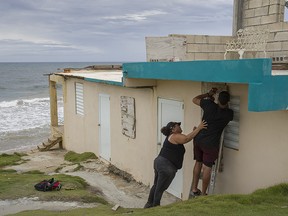Ya Mary Morales and Henry Sustache put plywood over the windows of their home as they prepare for the arrival of Tropical Storm Dorian on August 28, 2019 in Yabucoa, Puerto Rico. (Joe Raedle/Getty Images)