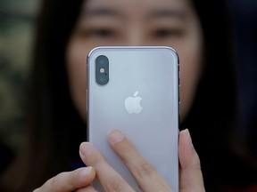 In this Oct. 31, 2017, file photo, an attendee uses a new iPhone X during a presentation for the media in Beijing, China.