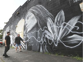 Artist David Derkatz, left, and Mister Maid owner David Burman check out the recently completed mural on Thursday, August 15, 2019, on the Ottawa St. business that was vandalized with spray paint.