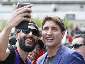 Justin Trudeau poses for a selfie with a Toronto Raptors fan during a rally at Nathan Phillips Square on June 17, 2019. Sources say the Liberals are set to make wireless bills a priority in the coming election.