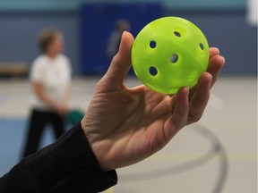 A player prepares to serve the ball during a game of pickleball.