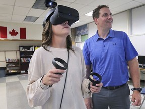 Julie Daragon a teacher with the Windsor Essex Catholic District School Board and Doug Sadler, principal of information technology, test out virtual reality equipment at St. Michael's Adult Secondary School in Windsor, ON. on Wednesday, August 28, 2019.