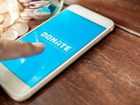 A finger pressing a donate icon button on a phone screen.
