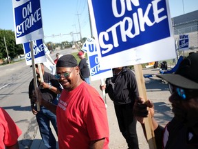 General Motors workers hold signs along the west side of the GM Powertrain Plant on September 18, 2019 in Toledo, Ohio. GM and the United Auto Workers union, which is leading its first strike against the auto maker since 2007, bargained into the evening yesterday and had plans to continue today over wages and health care, according to published reports citing sources familiar with the negotiations.