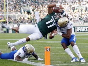 Connor Heyward of the Michigan State Spartans dives toward the end zone pylon for a 15-yard touchdown in the first quarter against Manny Bunch of the Tulsa Golden Hurricane at Spartan Stadium on August 30, 2019 in East Lansing, Michigan.