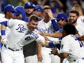 Ryan O'Hearn of the Kansas City Royals is swarmed by teammates at home plate after hitting a walk-off home run during the bottom of the 9th inning to win the game against the Detroit Tigers at Kauffman Stadium on September 03, 2019 in Kansas City, Missouri.