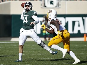 EAST LANSING, MI - SEPTEMBER 14: Brian Lewerke #14 of the Michigan State Spartans throws a pass while under pressure from Khaylan Kearse-Thomas #20 of the Arizona State Sun Devils in the first half of the game at Spartan Stadium on September 14, 2019 in East Lansing, Michigan.