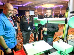 At last year's Emerging Technologies in Automation Conference and Trade Show at Caesars Windsor, Afzal Pahary, left, and Manir Al-Faisal, right, both of Shelley Automation, demonstrated their collaborative robot to a group of Magna engineers on Nov. 6, 2018.
