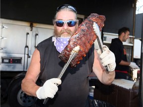 Tex Robert Jr. of River Ridge, Louisiana, prepares a rack of ribs during Windsor Rib and Craft Beer Festival Saturday afternoon.