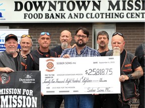Windsor Downtown Mission CEO Ron Dunn, centre, accepts a cheque for $25,818 from Luc Labelle, centre left, and Gary Poissionneault, centre right, and other Sober Sons MC riders on Friday, Sept. 6, 2019.  The money was raised from Sober Sons MC 11th annual On a Mission for the Downtown Mission motorcycle ride on August 25. Hundreds of riders participated in the ride from the Downtown Mission to Colchester.  The funds go toward stocking shelves at the mission's food bank.