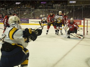 Erie Otters forward Maxim Golod, at left, puts a shot off the side of the net to the left of Windsor Spitfires goalie Kari Piiroinen during Saturday's game at the Erie Insurance Arena.