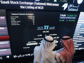 (FILES) In this file photo taken on November 12, 2014, Saudi investors monitor stocks at the exchange market department at the National Commercial  Bank (NCB) in Riyadh. - Saudi shares dropped three percent at the start of trading on September 15, 2019, the first session after drone attacks on two major oil facilities knocked out more than half the kingdom's production.