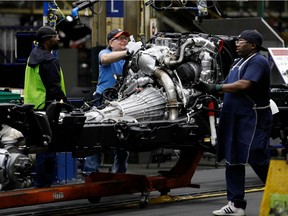(FILES) In this file photo taken on June 12, 2019 line workers work on the chassis of full-size General Motors pickup trucks at the Flint Assembly plant in Flint, Michigan. The United Auto Workers union called a strike against General Motors on September 15, 2019, with some 46,000 members set to walk off the job beginning at midnight amid an impasse in contract talks.Local union leaders met in Detroit "and opted to strike at midnight on Sunday," the UAW said on its Twitter account.