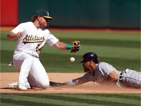 Detroit Tigers centre fielder Victor Reyes steals second base as Oakland Athletics second baseman Sheldon Neuse mishandles the throw during the eighth inning at Oakland Coliseum.