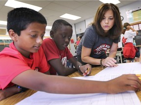 Tracy Bisnaire, a Grade 6 teacher at Sacred Heart Catholic Elementary School works with Denzel San Jacob, left, and Junior Amoah on Wednesday, September 25, 2019. The Windsor-Essex Catholic District School Board released their EQAO test results at the LaSalle school.