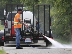 Chris McNamara with DBI Services uses a high-power washer to clean up graffiti at Little River Park in Windsor on Tuesday, Sept. 3, 2019.