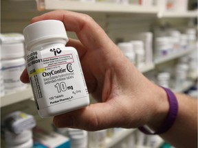 FILE PHOTO: A pharmacist holds a bottle OxyContin made by Purdue Pharma at a pharmacy in Provo, Utah, U.S., May 9, 2019.