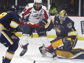 WINDSOR, ON. SEPTEMBER 26, 2019. -- Cole Purboo, centre, of the Windsor Spitfires chases a loose puck in front of Erie Otters' goalie Daniel Murphy and defensemen Luke Beamish during their game on Thursday, September 26, 2019, at the WFCU Centre in Windsor, ON.