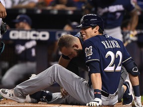 Christian Yelich of the Milwaukee Brewers is checked out by medical staff after fouling a ball off his knee at Marlins Park on September 10, 2019 in Miami. (Mark Brown/Getty Images)