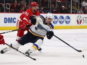 Brayden Schenn #10, of the St. Louis Blues, tries to control the puck in front of Luke Glendening #41, of the Detroit Red Wings, during the third period of Sunday's game at Little Caesars Arena.