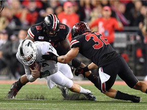 Quarterback Brian Lewerke of the Michigan State Spartans is sacked for a loss in the third quarter by Jashon Cornell of the Ohio State Buckeyes and Tuf Borland of the Ohio State Buckeyes at Ohio Stadium on October 5, 2019 in Columbus, Ohio. Ohio State defeated Michigan State 34-10.