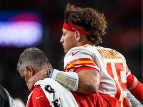 Patrick Mahomes #15 of the Kansas City Chiefs is helped off the field by trainers after sustaining an injury in the second quarter of a game against the Denver Broncos at Empower Field at Mile High on October 17, 2019 in Denver, Colorado.