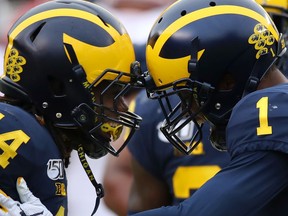 Ambry Thomas of the Michigan Wolverines celebrates a third quarter fourth down stop with Josh Metellus while playing the Rutgers Scarlet Knights at Michigan Stadium on September 28, 2019 in Ann Arbor, Michigan.