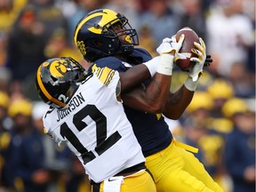 Nico Collins of the Michigan Wolverines makes a first quarter catch against D.J. Johnson of the Iowa Hawkeyes at Michigan Stadium on October 05, 2019 in Ann Arbor, Michigan.