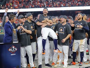 Jose Altuve of the Houston Astros gets lifted off his feet after being named ALCS MVP following his team's 6-4 win over the New York Yankees in Game 6 at Minute Maid Park on October 19, 2019 in Houston, Texas. (Photo by Elsa/Getty Images)