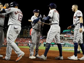 George Springer #4 of the Houston Astros is congratulated by his teammates after hitting a two-run home run against the Washington Nationals during the ninth inning in Game Five of the 2019 World Series at Nationals Park on Oct. 27, 2019, in Washington, DC.