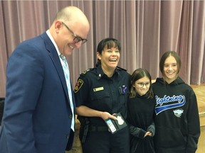 Mayor Drew Dilkens makes a surprise announcement at St. Gabriel Catholic Elementary School that Acting Police Chief Pam Mizuno has been named Windsor Police Chief, on Friday, Oct. 4, with Mizuno's children Emily and Natalie Garro beside her.