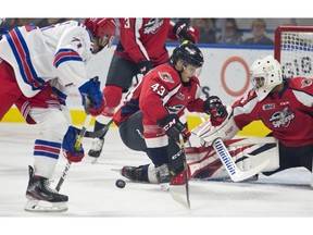 Kitchener Rangers rookie forward Francesco Pinelli takes a shot at Windsor Spitfires goalie Xavier Medina as Windsor defenceman Louka Henault  braces during first-period  action on Friday in Kitchener.