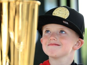 Raptors fan Bentley Wallace, 7, stares at the Larry O'Brien Championship Trophy during the Windsor stop of the MilkUP Trophy Tour at Charles Clark Square Saturday. Visitors had to sign a waiver, promising to not touch the gleaming hardware.  Photographs and staring were permitted.