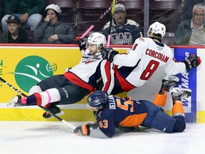 Windsor Spitfires Chris Playfair, left, and Connor Corcoran are taken down by Flint Firebirds Ty Dellandrea in first period action from WFCU Centre Thursday.