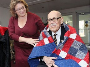 U.S. Army veteran William Moss, 89, receives a U.S. Quilt of Valor from Anna Donatucci during a ceremony at Windsor's Kensington Court Retirement Residence on Friday.  Moss served from 1950-52 in the Korean War.