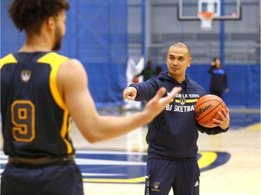 Windsor, Ontario. October 21, 2019. Windsor Lancers head coach Chris Cheng run drills as Lancers prepare for opening night of 2019 OUA basketball season. Lancers Kanayo Nnadi has back to camera, listens to instructions.