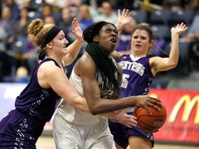 University of Windsor Lancers Olivia Osamusali, centre, drives against Western University Mustangs Brett Fischer, left, and Ariane Saumure in OUA women's basketball Wednesday.