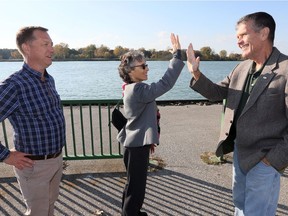 Dianne Saxe, centre, gives John Hartig a high five after learning from Hartig and University of Windsor associate professor Trevor Pitcher, left, that numbers of sturgeon on the Detroit River have increased significantly since the installation of nine artifical reefs, manmade habitat for the fish to spawn.  Saxe was touring the Great Lakes Institute for Environmental Studies.