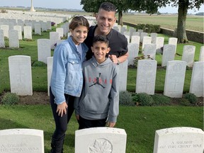 Eddie Francis poses with his children, Sienna, 12, and Phoenix, 10, at the gravesite of the youngsters' great-great grandfather, Pte. William Prince, at the Adanac Military Cemetery, a Commonwealth war graves burial ground in northern France on Monday, Oct. 14, 2019.