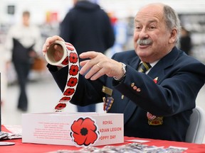 Canadian Forces veteran Earl Jones tries to get the attention of children and their parents while handing out poppy stickers at Walmart on Tecumseh Road East Thursday.  Jones was joined by his wife Diane Jones at a Royal Canadian Legion Poppy Day table just inside the doors.