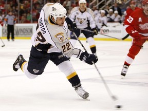 Jordin Tootoo of the Nashville Predators takes a slap shot in front of Kris Draper  of the Detroit Red Wings during game two of the 2008 NHL Western Conference Quarterfinals on April 12, 2008 at Joe Louis Arena in Detroit, Michigan.