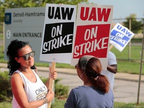 In this Sept. 22, 2019, photo, Coianne Abant, left, a member of United Auto Workers Local 598, and supporters picket outside of General Motors Detroit-Hamtramck Assembly in Detroit, Mich.