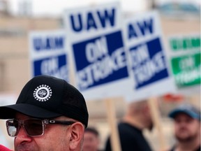 In this Sept. 16, 2019, file photo, David Garcia, a United Auto Workers member who is employed at the General Motors Co. Flint Assembly plant in Flint, Mich., pickets outside of the plant as they strike.