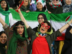 Iranian women cheer during the World Cup Qatar 2022 Group C qualification soccer match between Iran and Cambodia at the Azadi stadium in the capital Tehran on Oct. 10, 2019. The Islamic republic has barred female spectators from soccer and other stadiums for around 40 years, with clerics arguing they must be shielded from the masculine atmosphere and sight of semi-clad men. Women fans are attending the soccer match freely for the first time in decades, after FIFA threatened to suspend the country over its controversial male-only policy.