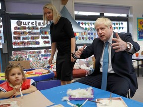 Britain's Prime Minister Boris Johnson gestures as he participates in an art class with four year-old Scarlet Fickling at St Mary's and All Saints Primary School in Beaconsfield, Buckinghamshire on Oct. 11, 2019.